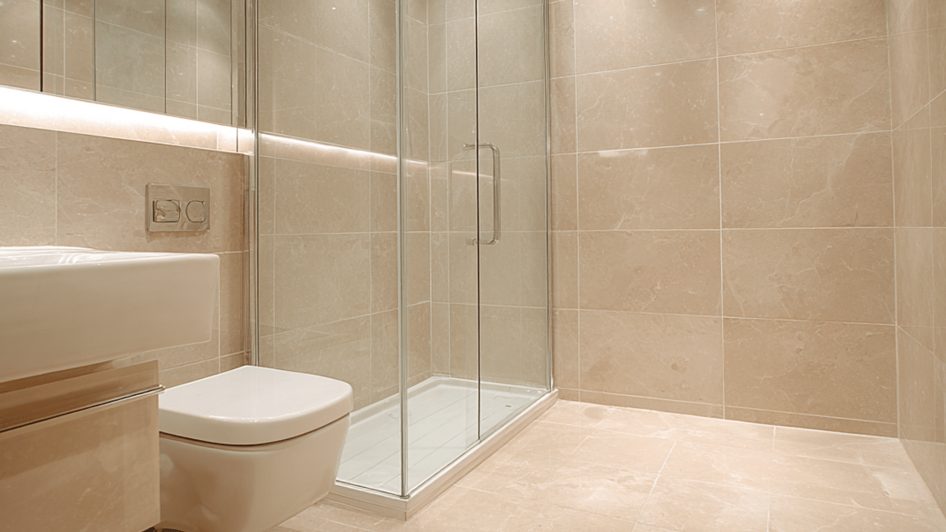 A modern bathroom featuring a shower and toilet, adorned with large format tiles for a sleek appearance