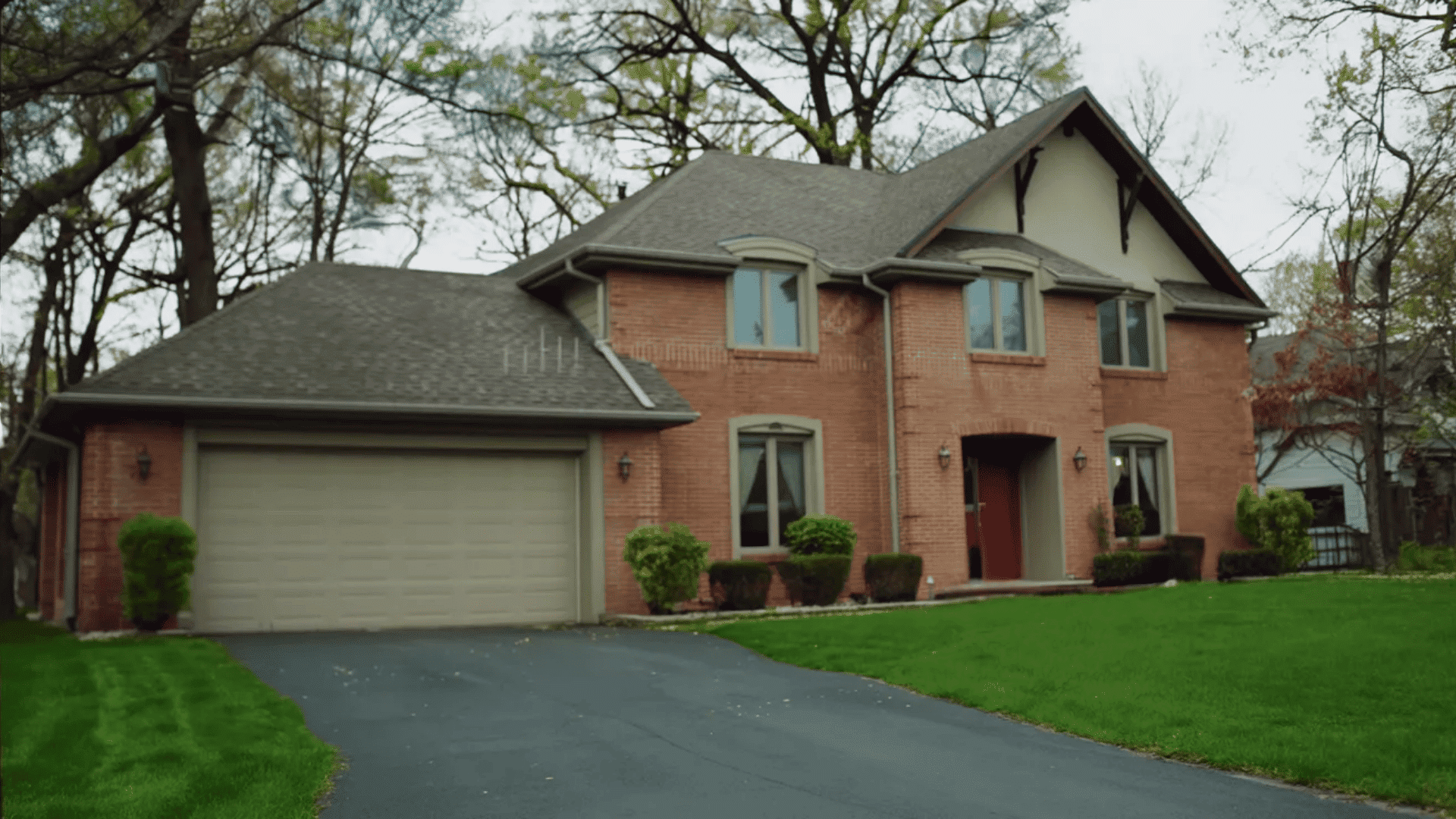 A large brick house featuring a driveway and an attached garage