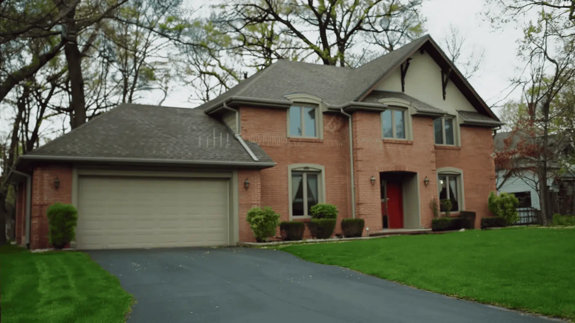 A large brick house featuring a driveway and an attached garage
