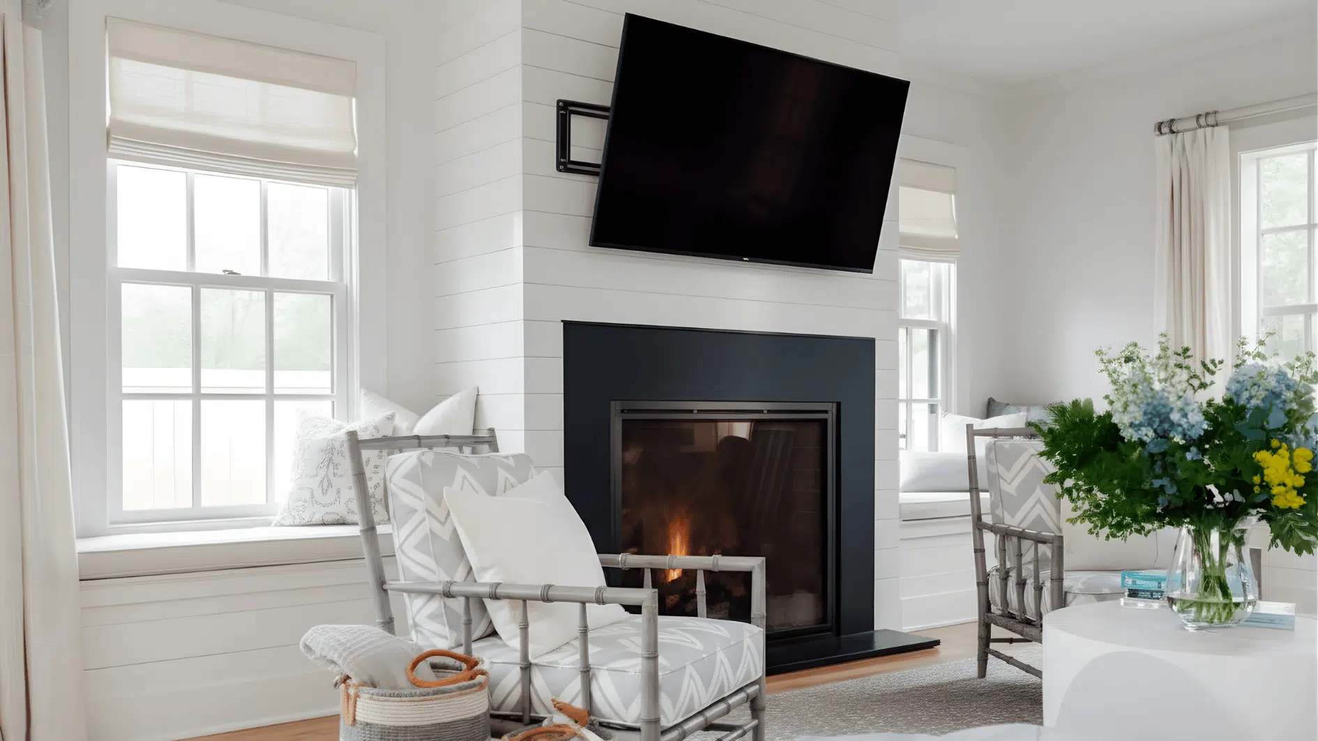 A living room featuring white walls, a fireplace, and a TV mounted above the low mantel, tilted for optimal viewing.