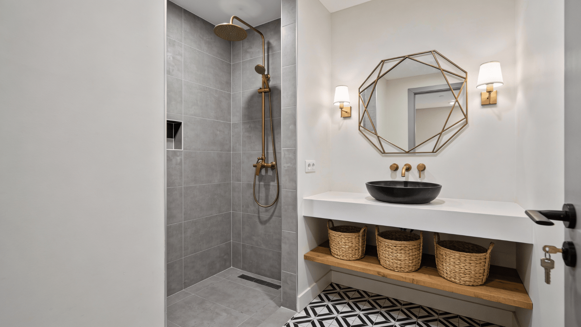 A modern doorless walk in shower with a short entry wall, gray tile, and a sleek rainfall showerhead beside a stylish vanity
