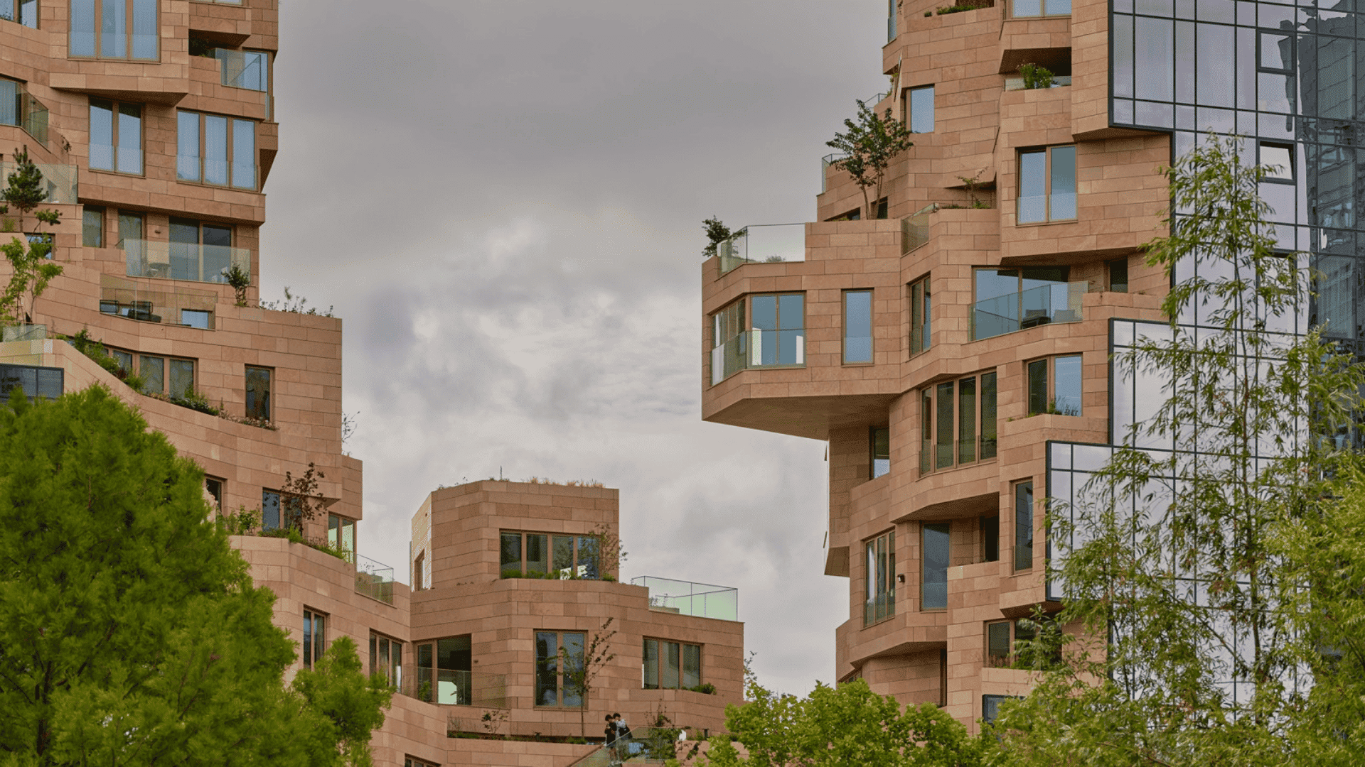 A multi-story building featuring numerous windows and balconies on its facade which provides it a dense look with clear sky.