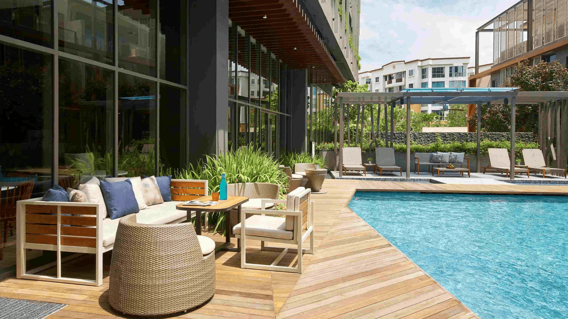 A view of the hotel pool area, furnished with seating and tables, creating a comfortable space for guests to unwind