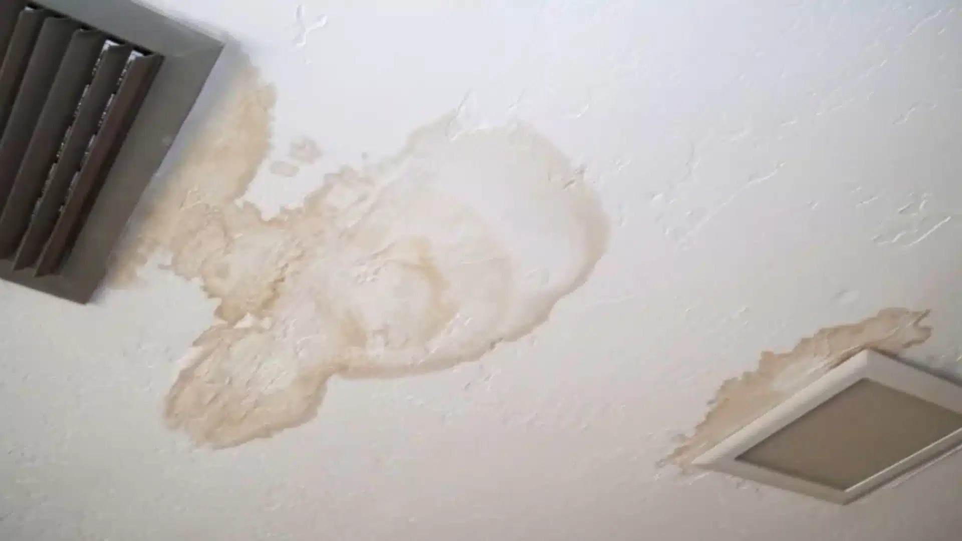 Ceiling in a attic showing water damage, possibly due to leaks from a vent or skylight