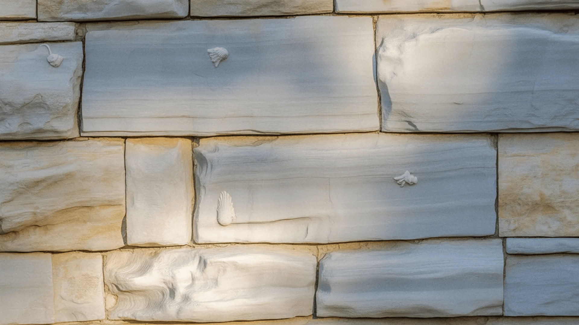 A textured stone wall featuring a variety of shapes and sizes of natural stone patterns and colors