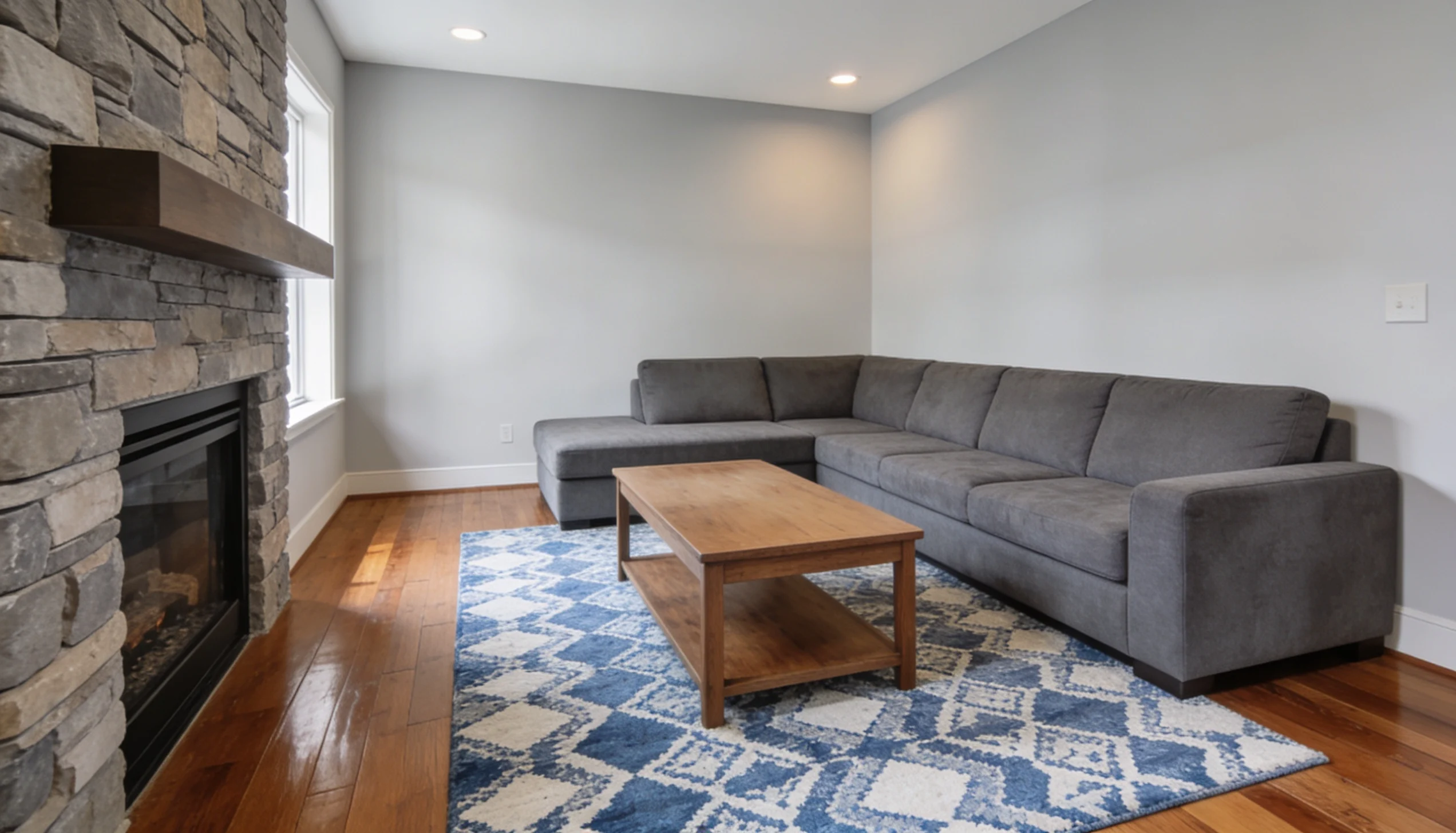A cozy living room featuring a couch, coffee table, and a warm fireplace, creating an inviting atmosphere