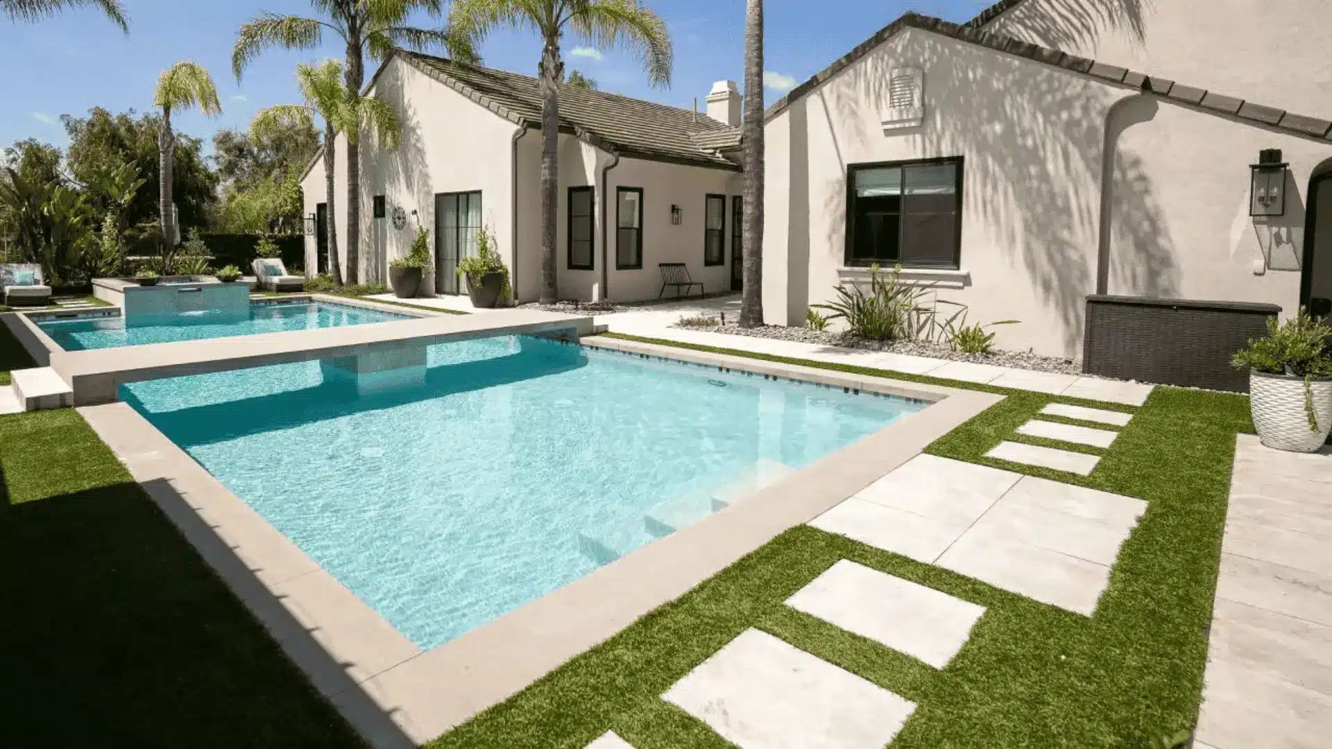 Modern backyard pool with stepping stone walkway, palm trees, and clean white exterior