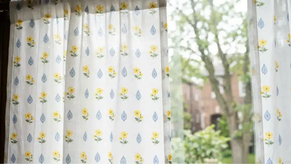 A window adorned with a yellow and blue floral curtain, adding a vibrant touch to the room's decor.
