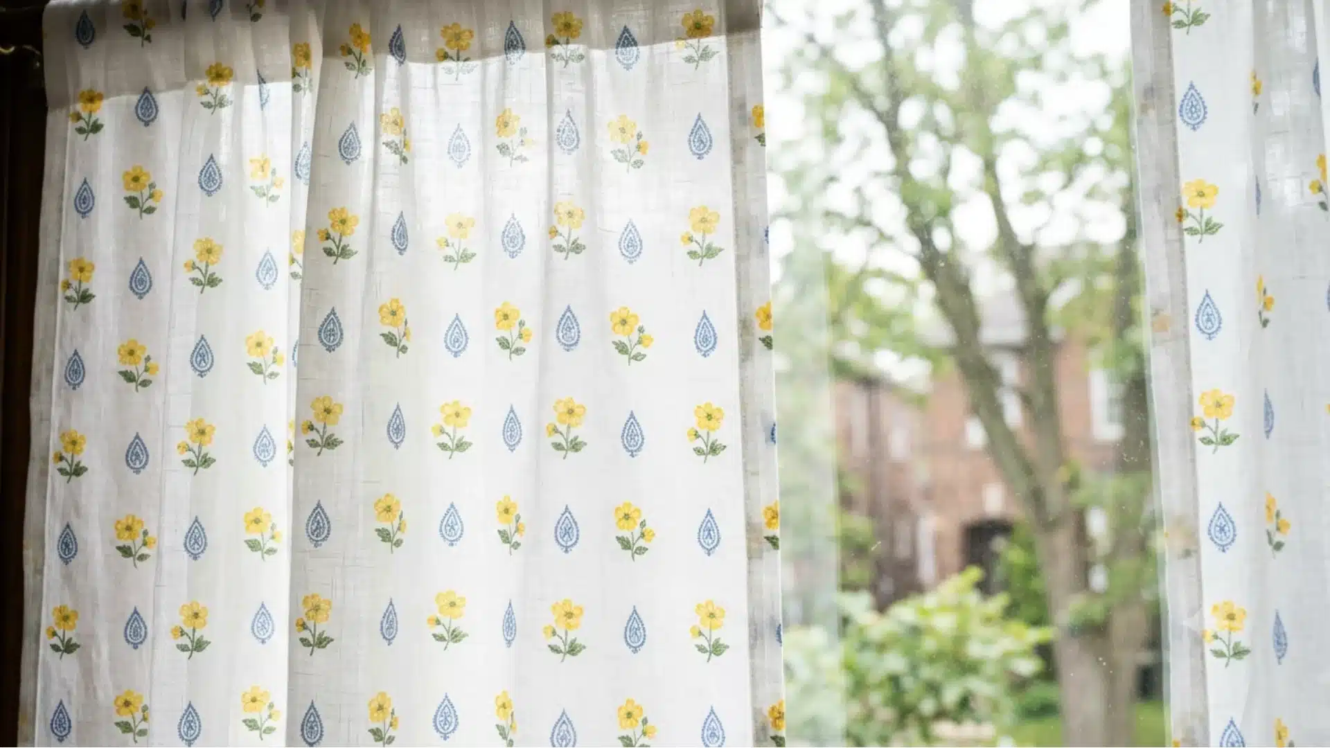 A window adorned with a yellow and blue floral curtain, adding a vibrant touch to the room's decor.