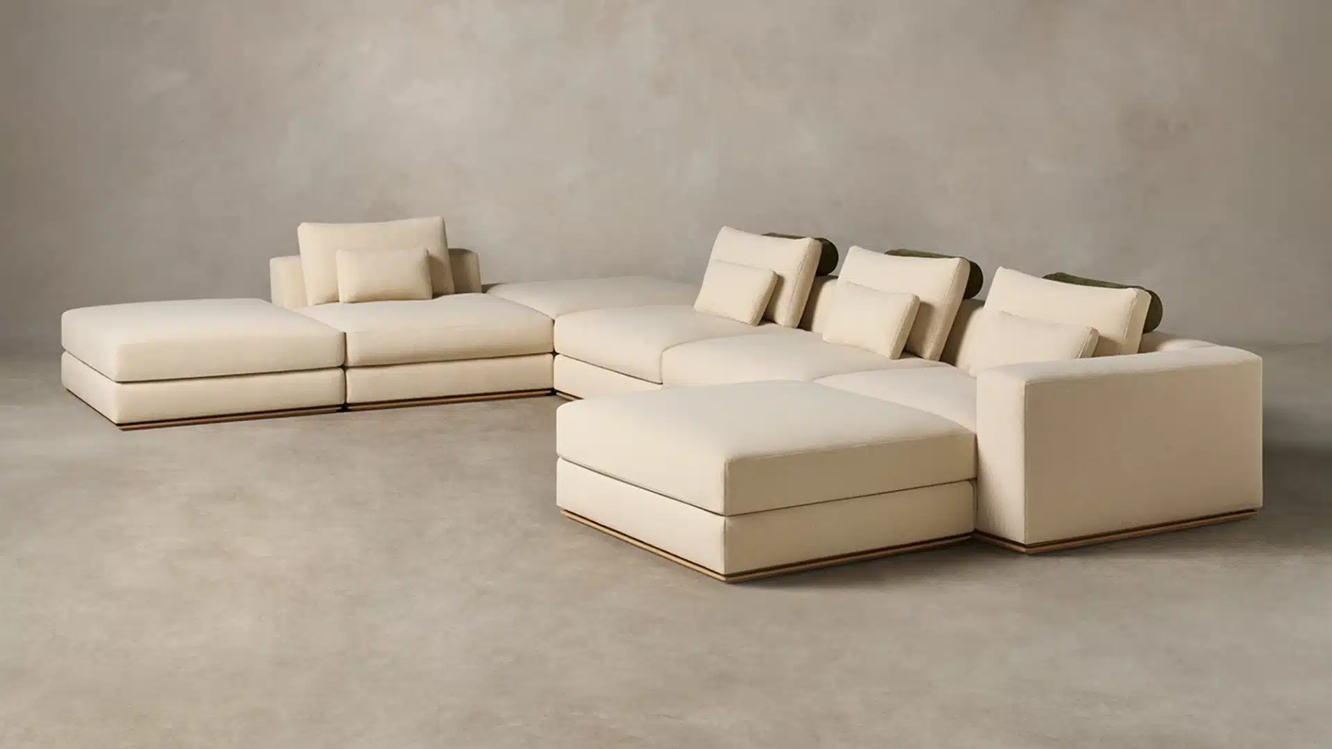 Cream modular sectional sofa with chaise lounges, adjustable headrests, and matching cushions in a minimalist neutral room.