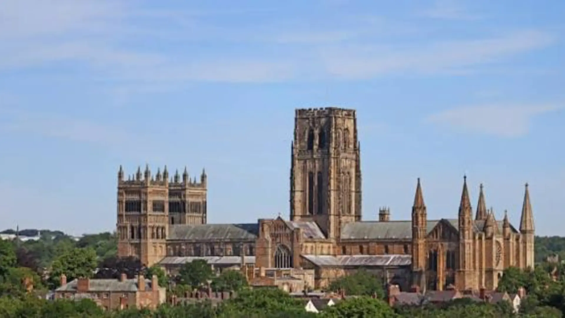 Durham Cathedral, a historic Norman cathedral with large stone towers and pointed spires above the surrounding town.