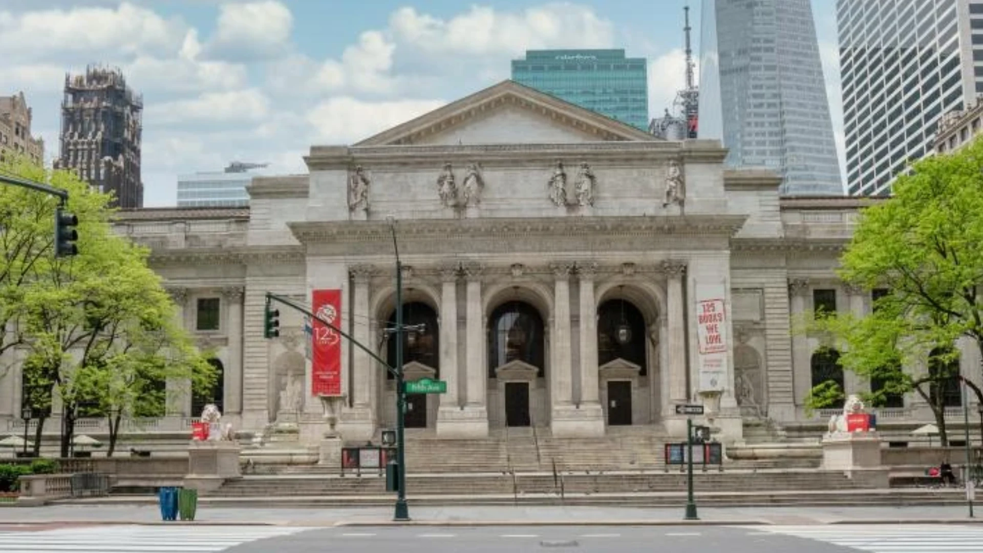 New York Public Library facade with broad entrance steps classical columns arched doors stone sculptures and city towers
