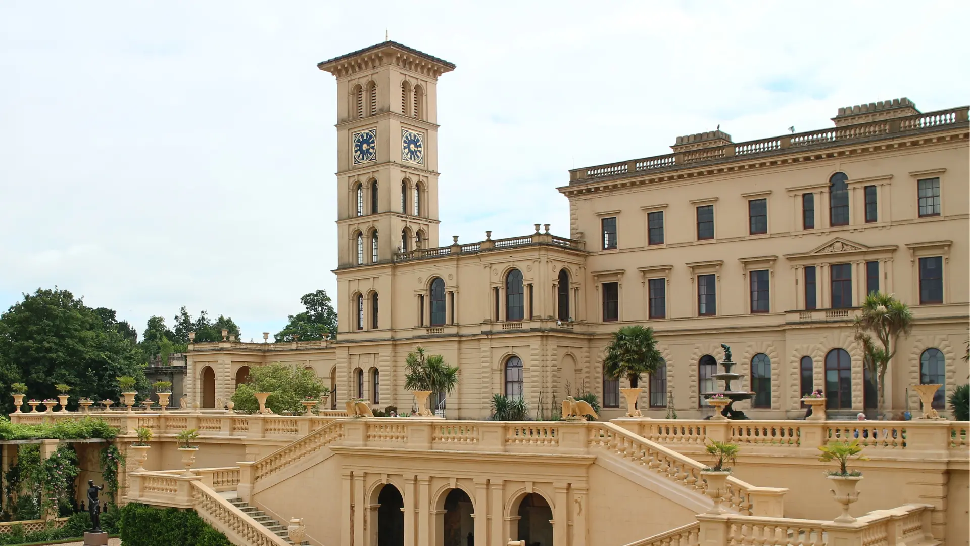 Grand Italianate mansion with tall tower arched windows stone terraces balustrades and landscaped formal gardens