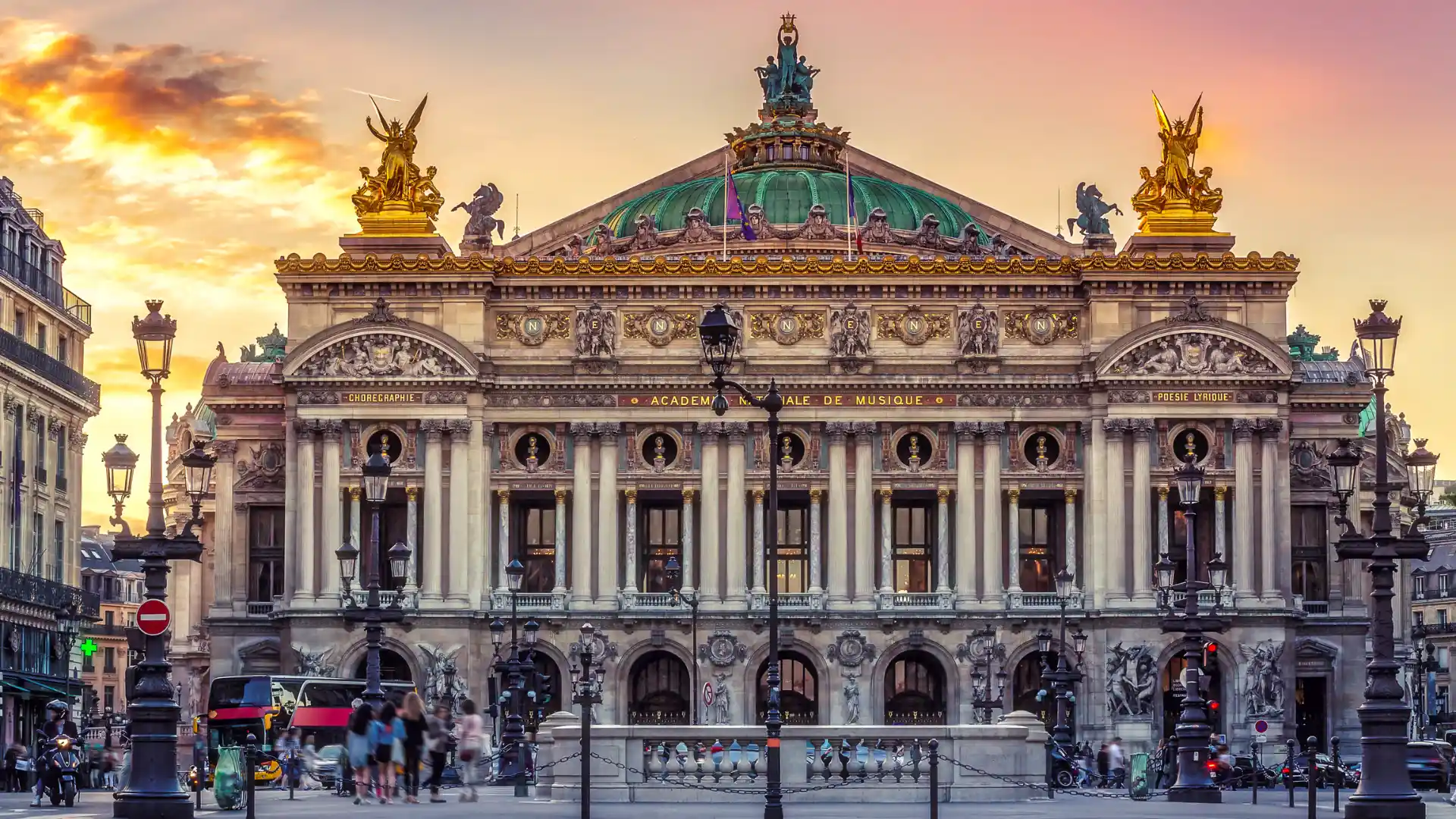 Palais Garnier facade at sunset with grand columns arched openings gold statues green dome and ornate stone details